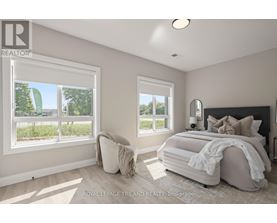 A bedroom with a large bed and a window overlooking a green area.