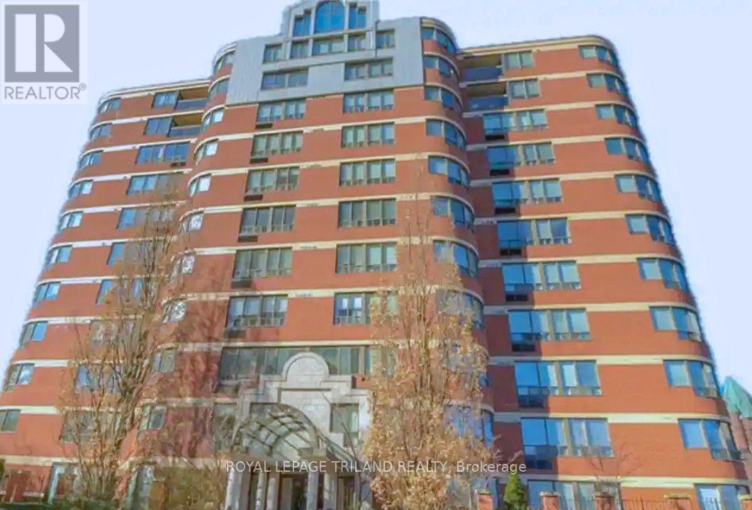 A tall building with a curved design at the top and a balcony on the side.