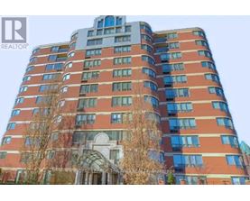 A tall building with a curved design at the top and a balcony on the side.