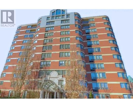 A tall building with a curved design at the top and a balcony on the side.