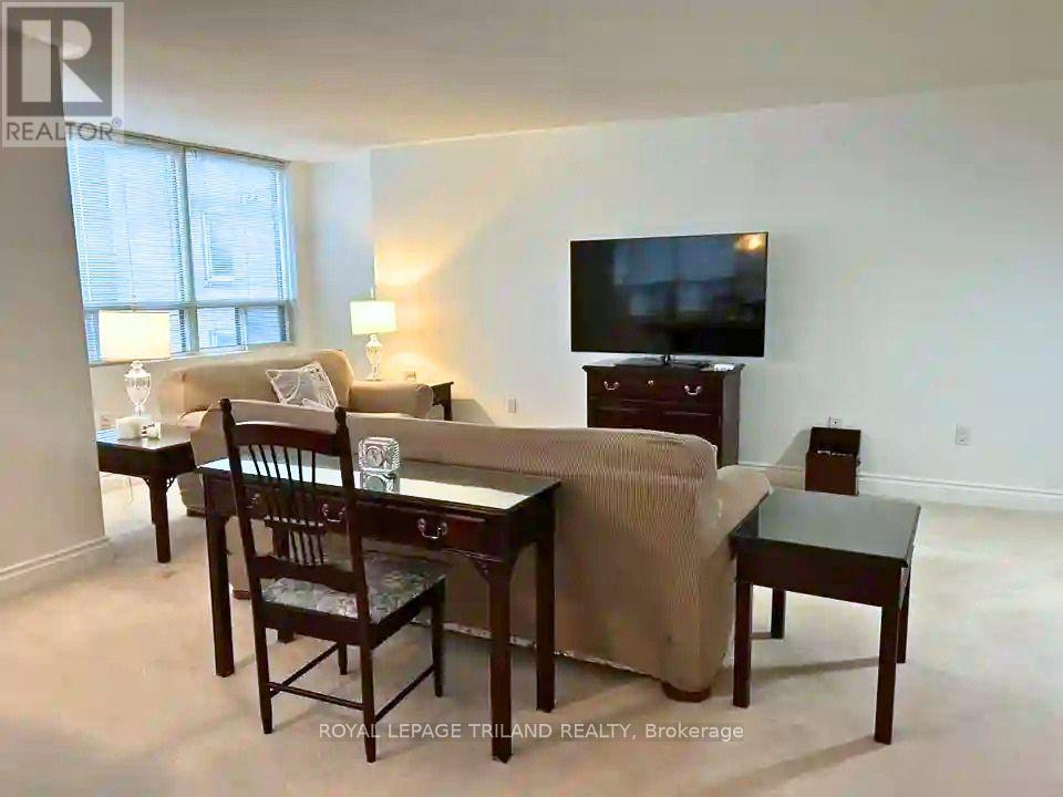 A living room with a brown couch, a wooden table, and a television.