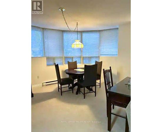 A dining room with a table and chairs.