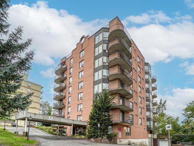 A multi-story residential building with balconies and a Centino sign on the ground.