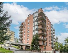 A multi-story residential building with balconies and a Centino sign on the ground.