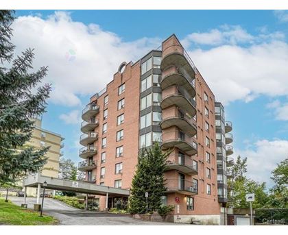 A multi-story residential building with balconies and a Centino sign on the ground.