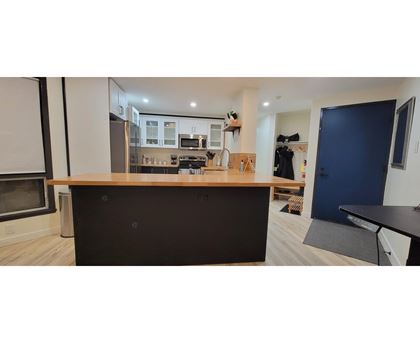 A kitchen with a black countertop and a blue door.