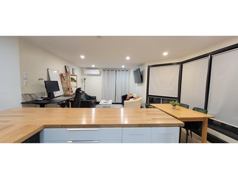 A room with a desk, chairs, and a whiteboard.