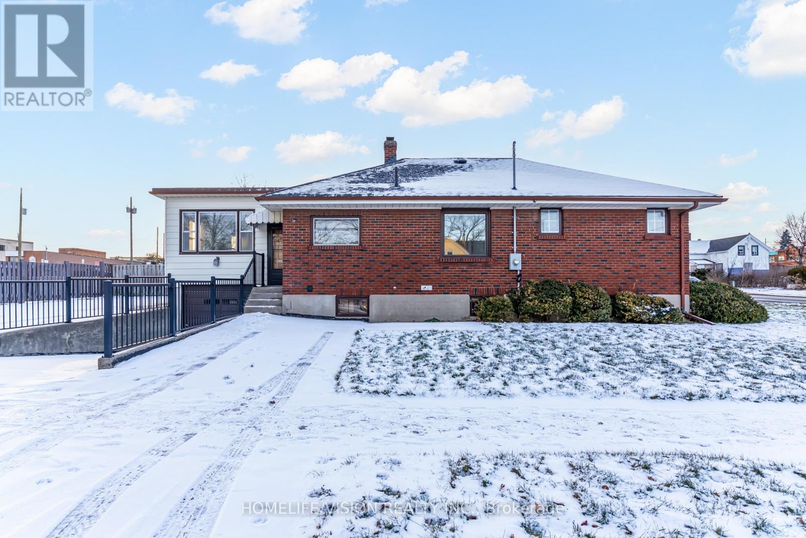 A house with a snow-covered ground in front of it.