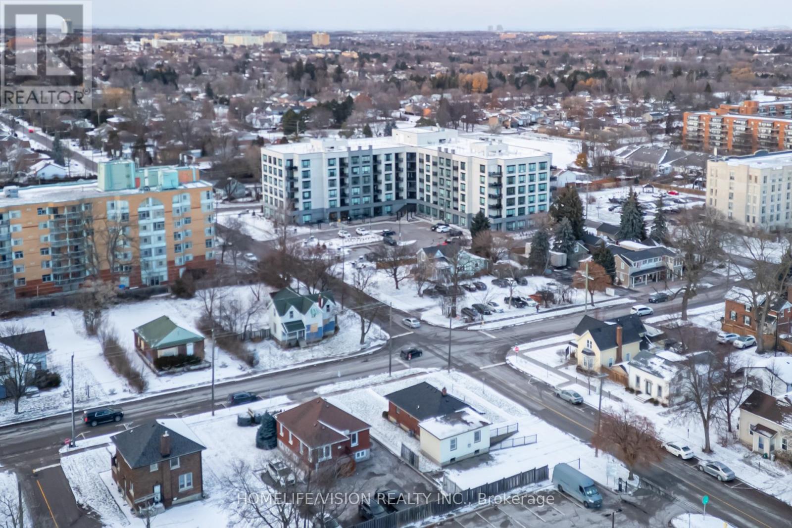 A winter scene of a residential area with houses and apartment buildings.