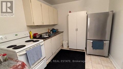 A kitchen with white appliances and cabinets.