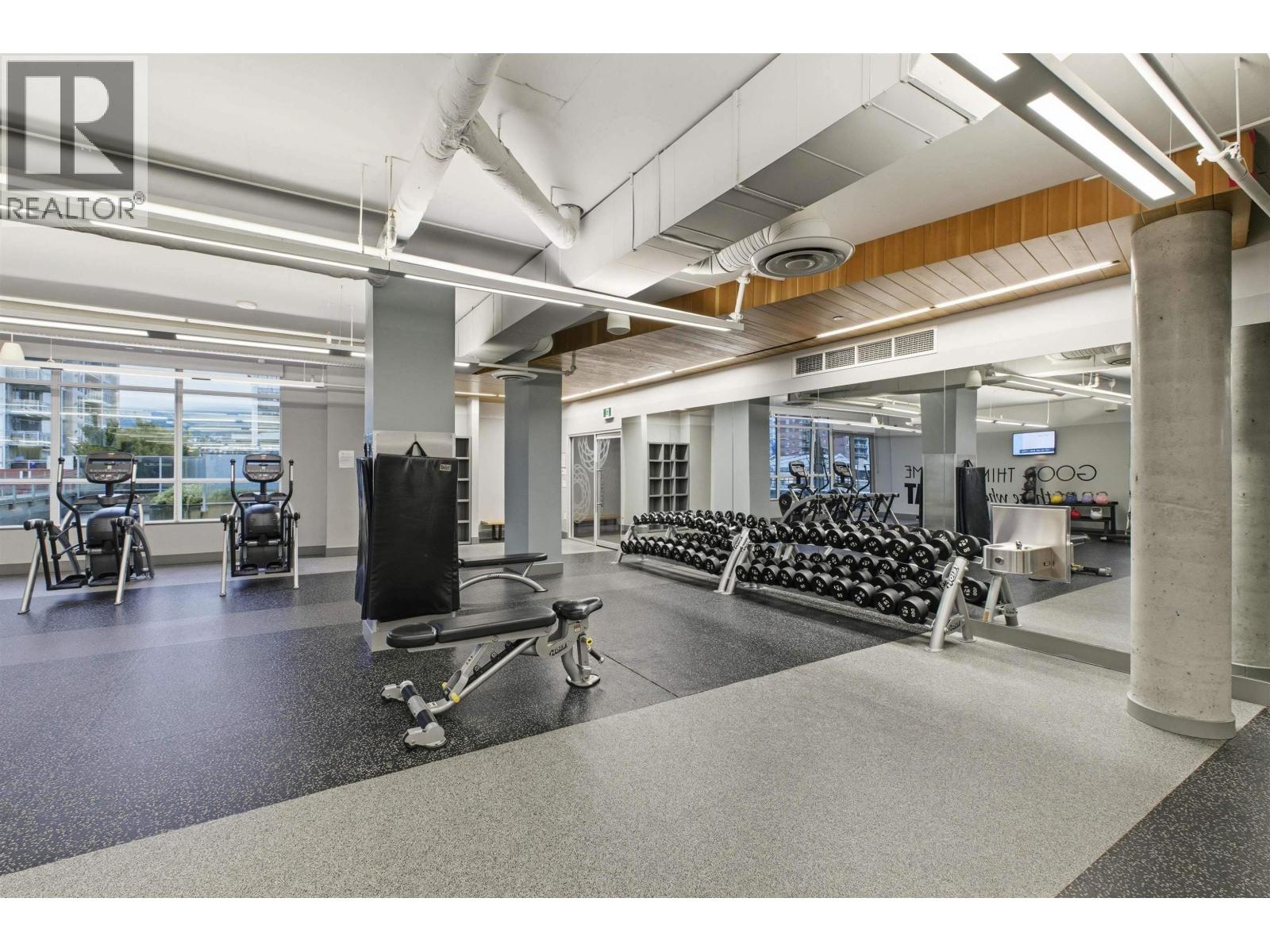 A gym with a variety of equipment including treadmills, weights, and exercise machines.