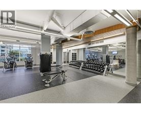 A gym with a variety of equipment including treadmills, weights, and exercise machines.