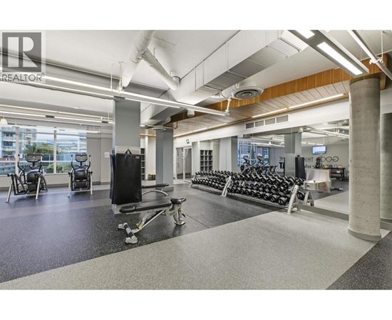 A gym with a variety of equipment including treadmills, weights, and exercise machines.