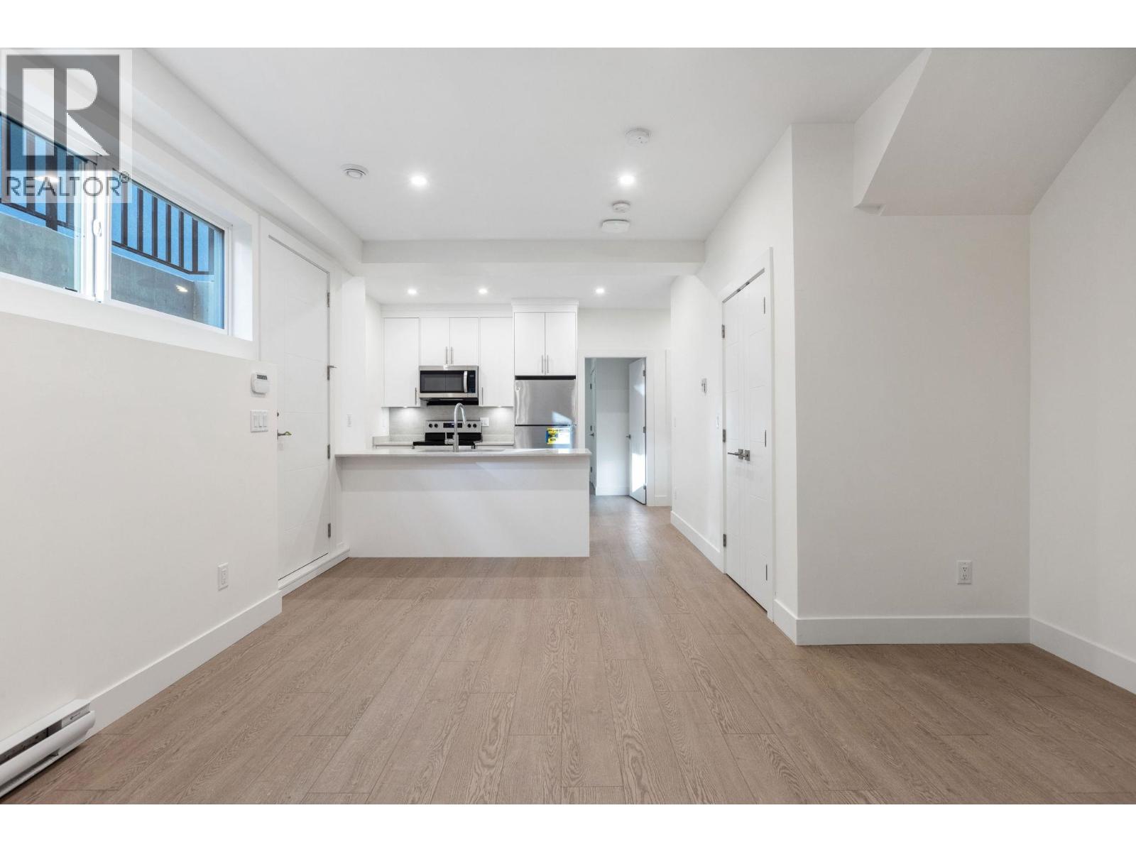 A spacious room with a kitchen area in the middle.