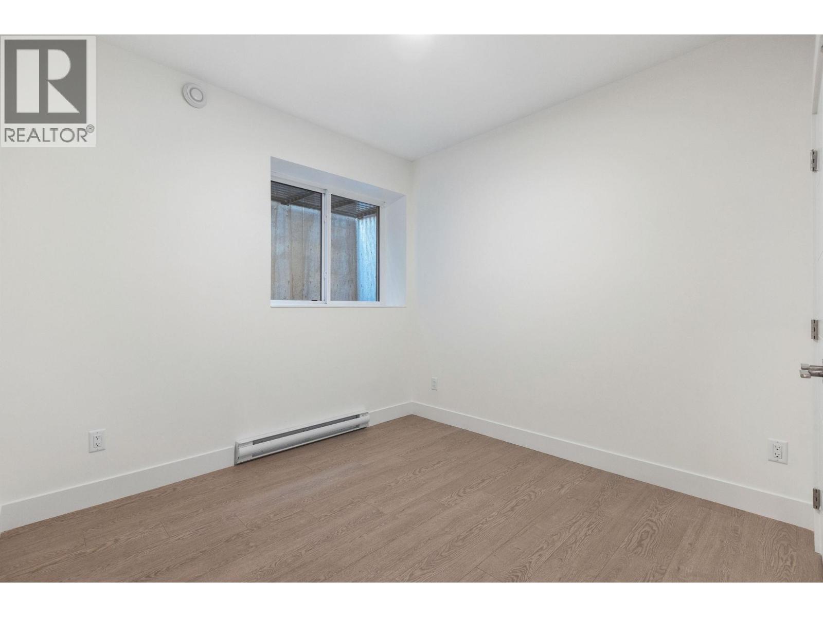 A room with a window and a wall-mounted air conditioner.