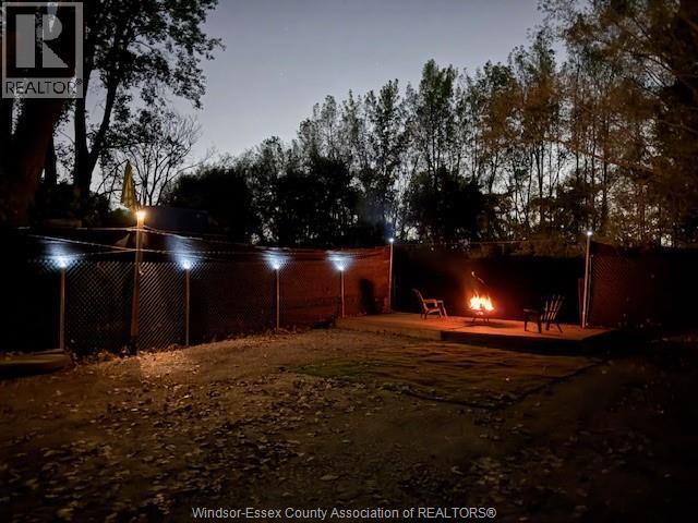 A backyard with a fire pit and chairs.