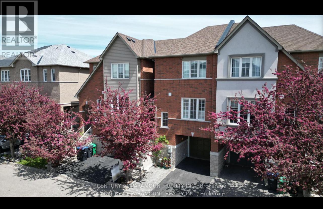 A row of houses with trees in front of them.