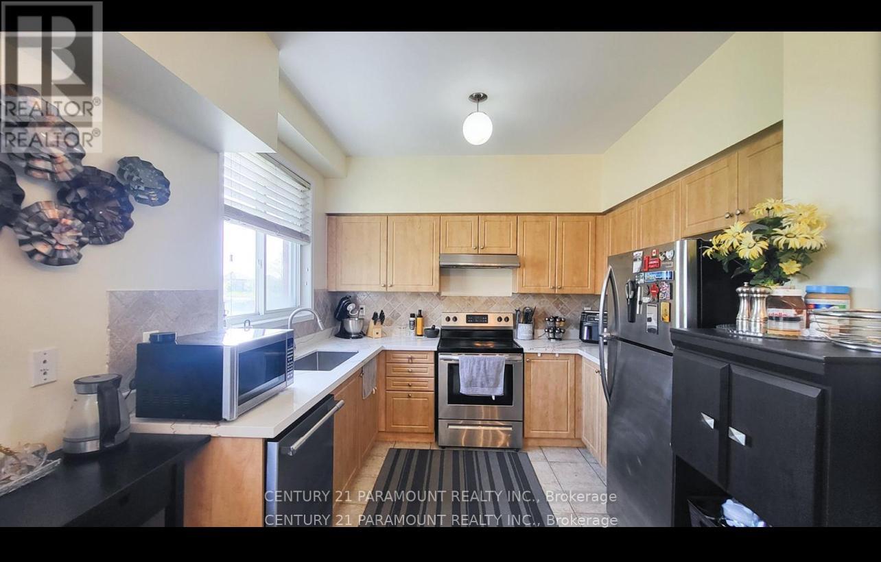 A kitchen with wooden cabinets and black appliances.