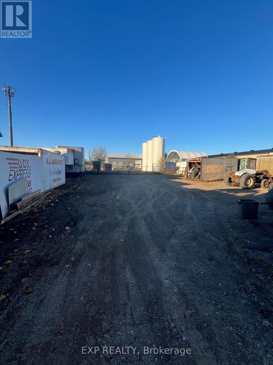 A dirt road with a truck and a trailer in the distance.