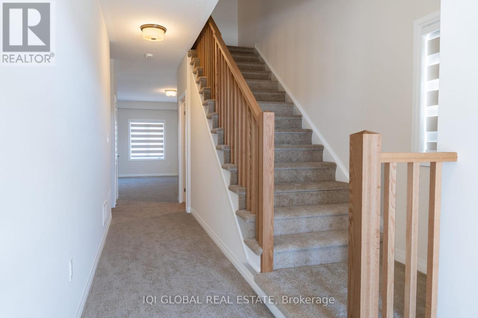 A hallway with a staircase leading to the second floor.