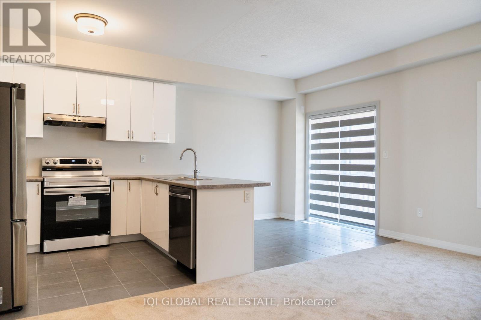 A kitchen with white cabinets and a black oven.