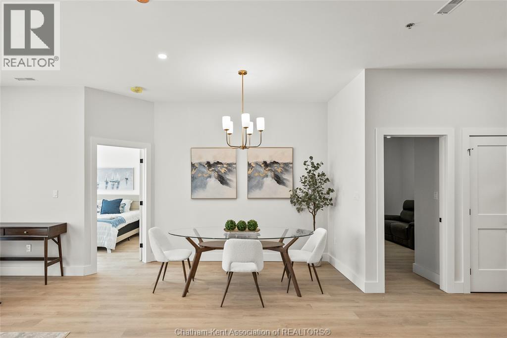 A well-lit dining room with a wooden table and chairs.