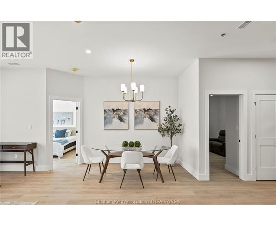 A well-lit dining room with a wooden table and chairs.