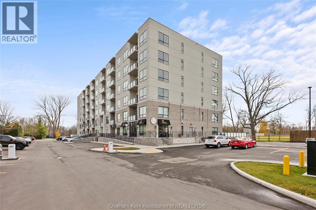 A large apartment building with a parking lot in front.