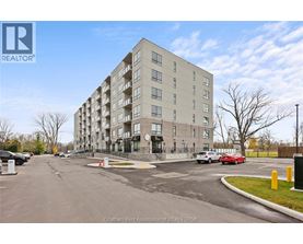 A large apartment building with a parking lot in front.