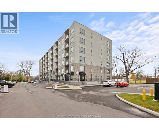 A large apartment building with a parking lot in front.