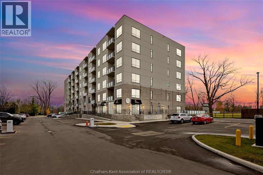 A large apartment building with a parking lot in front of it.