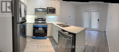 A kitchen with white cabinets and a blue dishwasher.