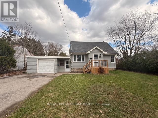 A house with a grey roof and a white garage door is for sale.