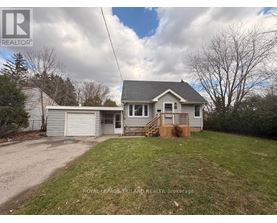 A house with a grey roof and a white garage door is for sale.