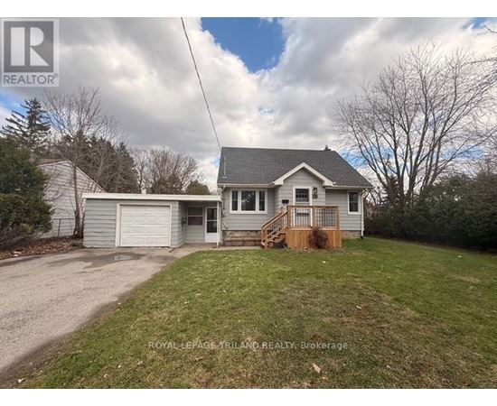 A house with a grey roof and a white garage door is for sale.