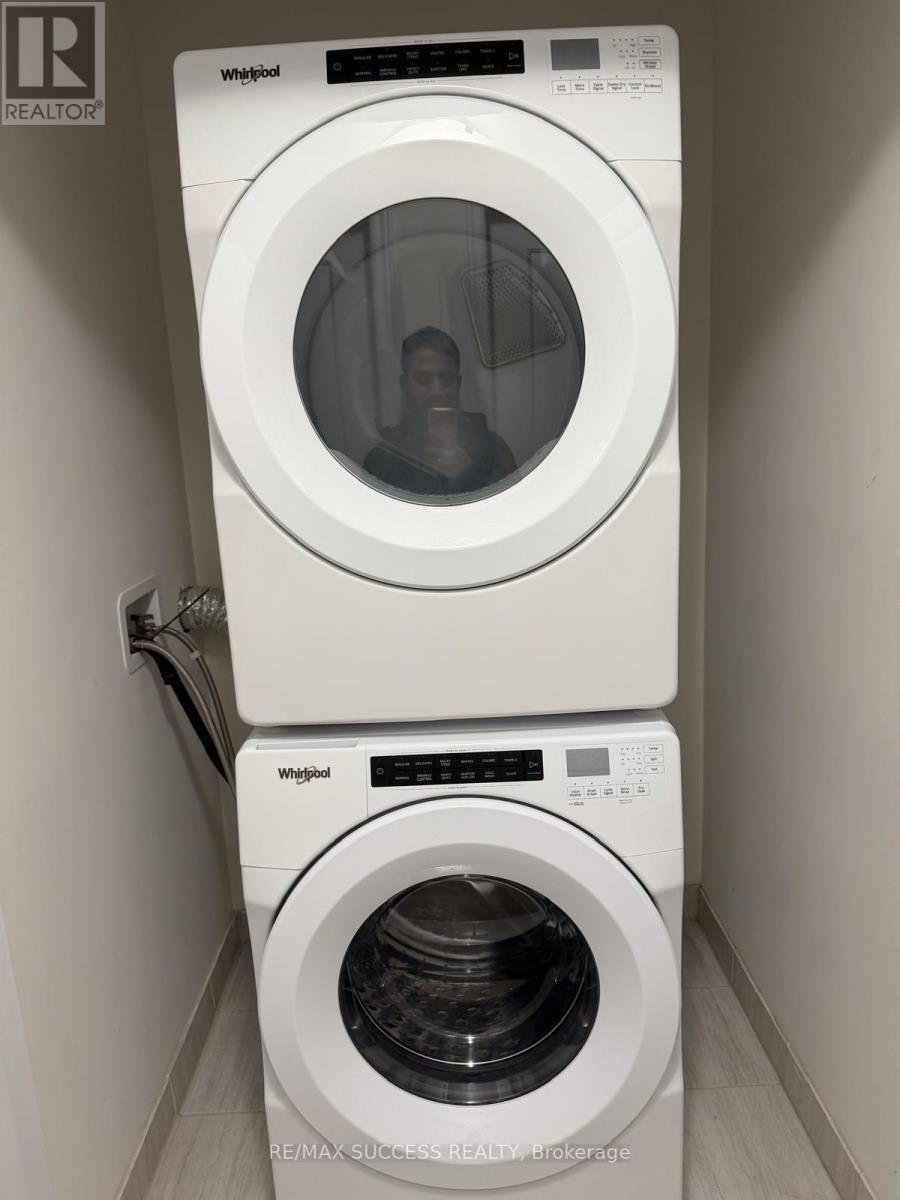A white Whirlpool washing machine and dryer in a small laundry room.