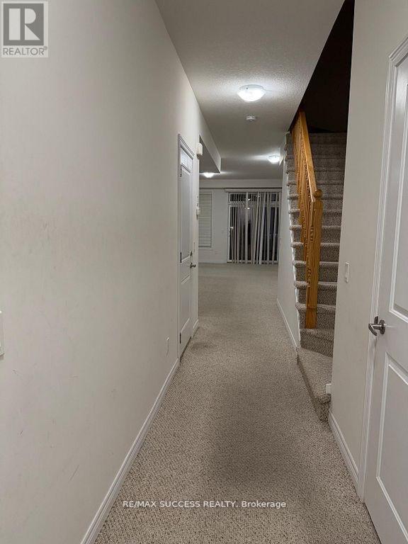 A hallway with a carpeted floor and white walls.