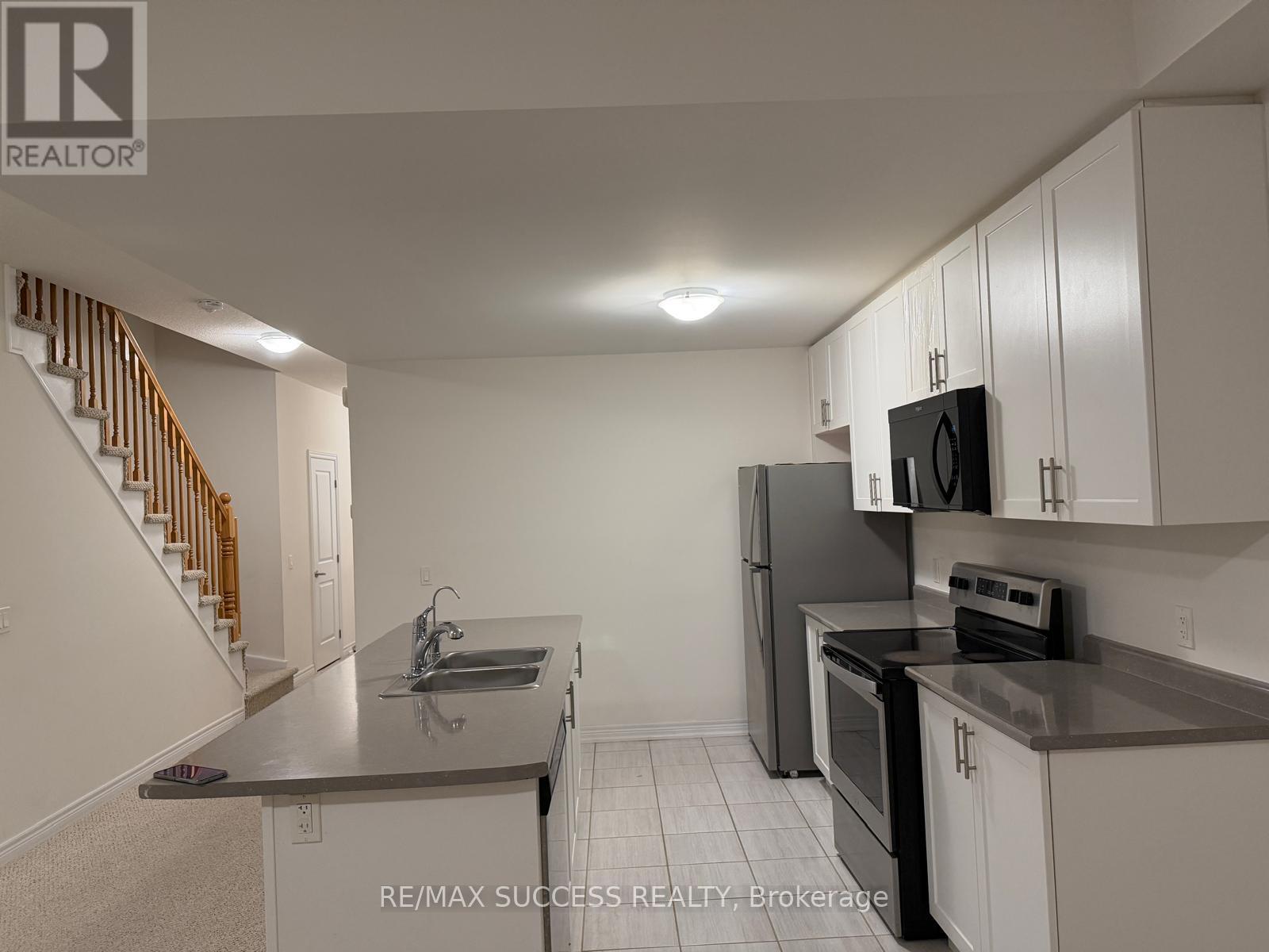 A kitchen with white cabinets and black appliances.