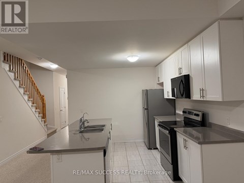 A kitchen with white cabinets and black appliances.