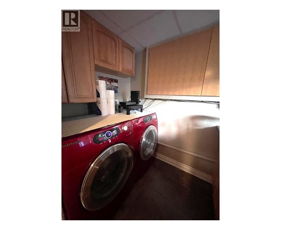 A red washing machine in a kitchen.