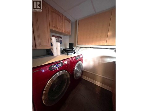 A red washing machine in a kitchen.