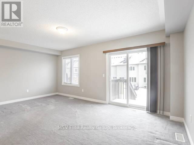 A spacious room with a sliding glass door leading to a balcony.