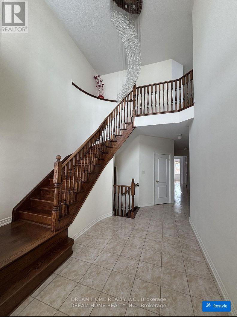 A staircase with a wooden handrail and tiled flooring.