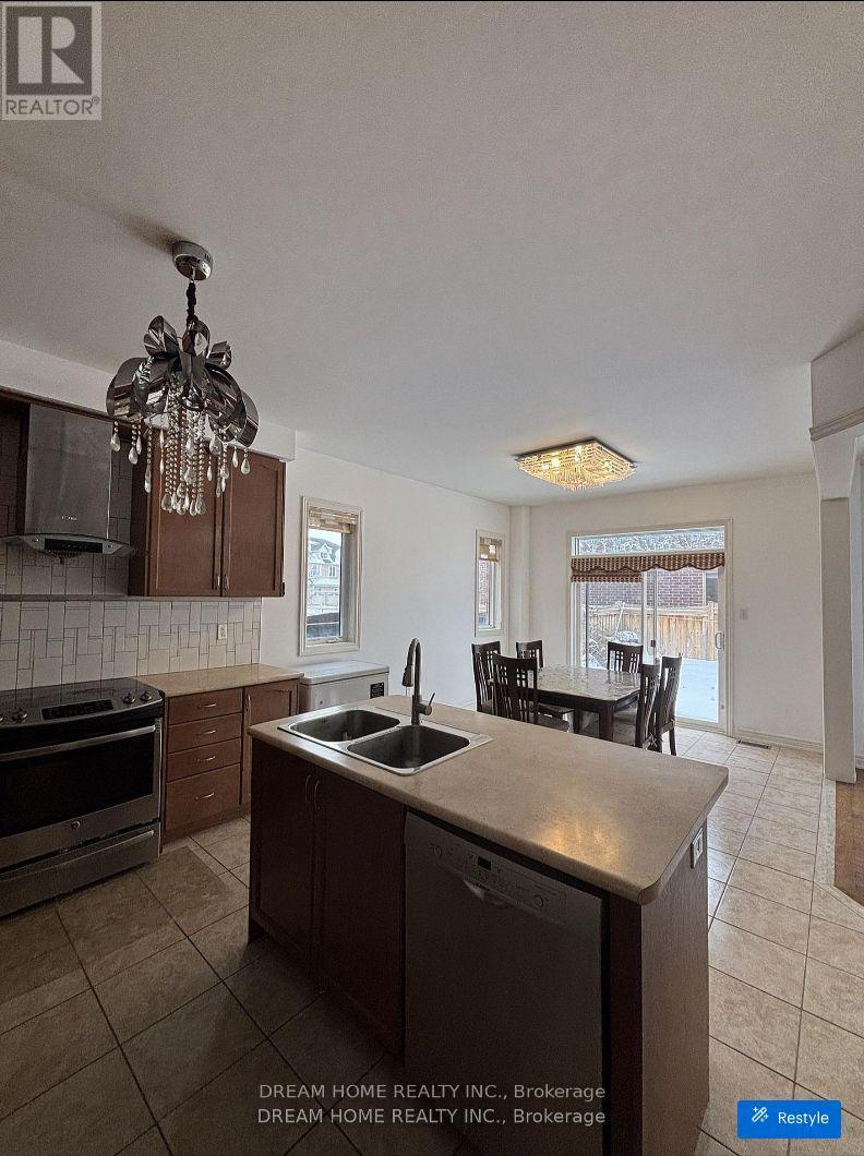 A kitchen with a stove, sink, and chairs.