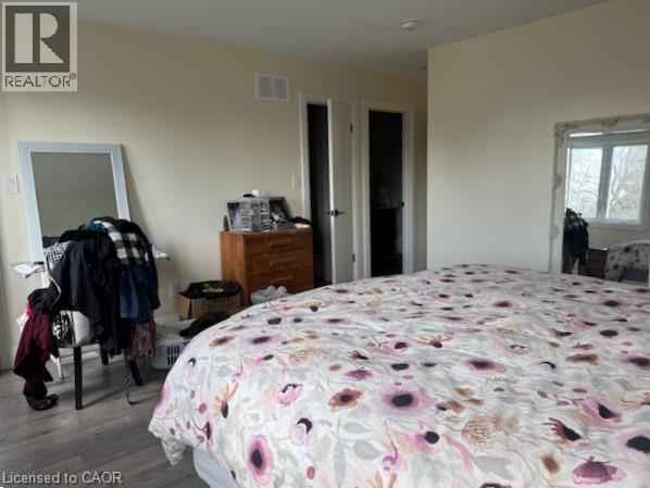 A bedroom with a floral bedspread and a mirror on the wall.