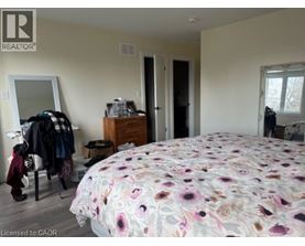 A bedroom with a floral bedspread and a mirror on the wall.