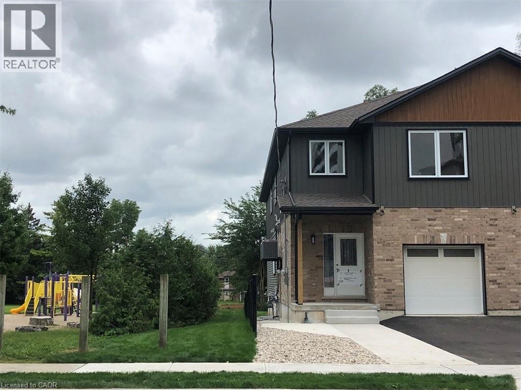 A house with a garage and a playground in the yard.