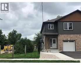 A house with a garage and a playground in the yard.