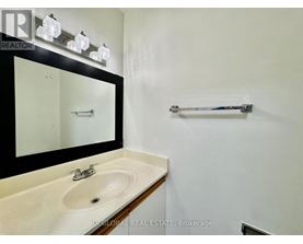 A bathroom with a sink, mirror, and towel bar.