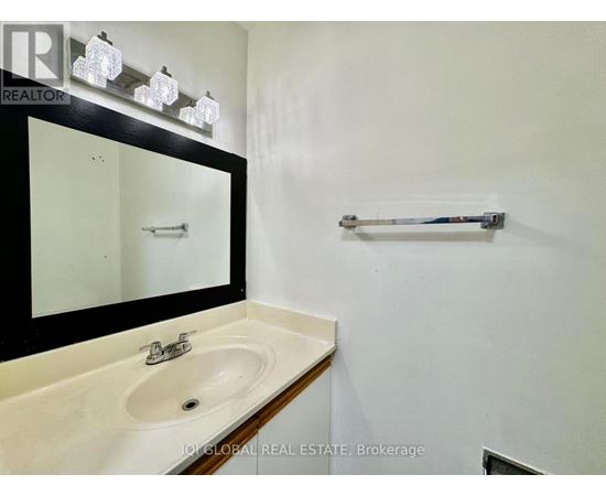 A bathroom with a sink, mirror, and towel bar.